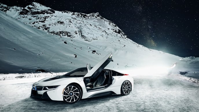 A white BMW I8 on the mountains with snow