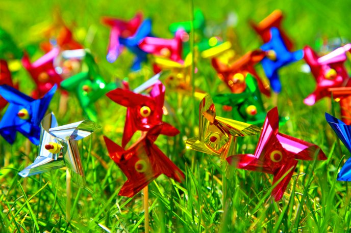 Colourful paper vanes in the green grass of spring
