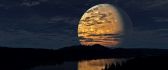 Big yellow moon reflected in river water