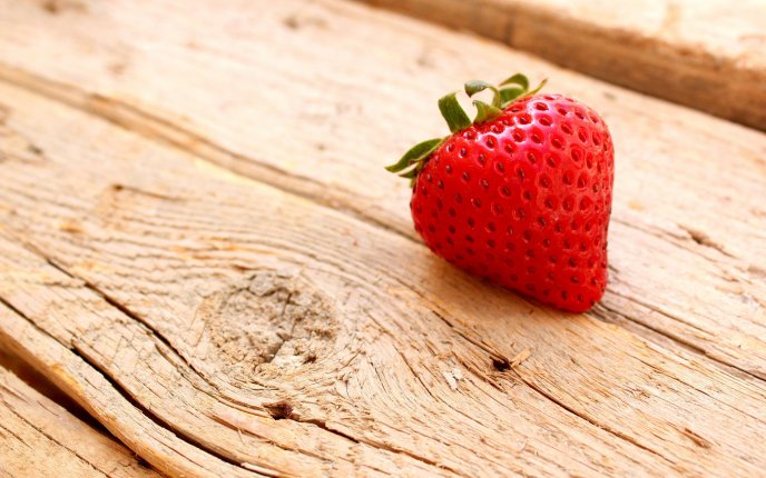 A delicious strawberry on a piece of wood