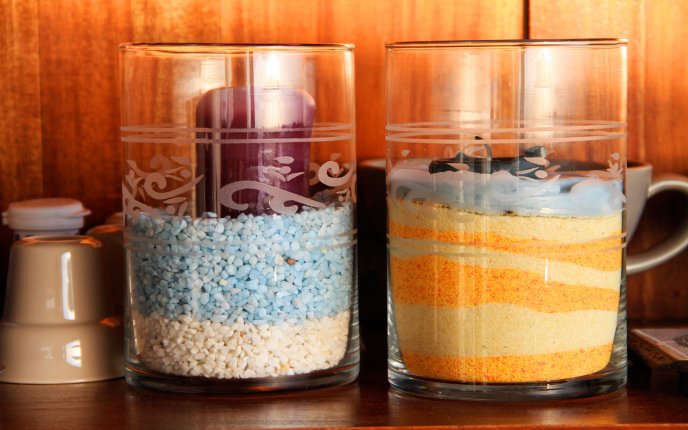 Colored candles in jars with sand