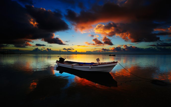 Anchored boat at sea at sunset