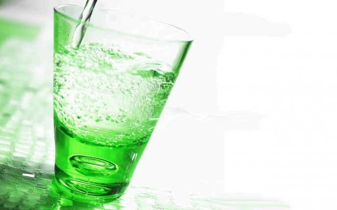 Fresh mineral water in a glass - green light