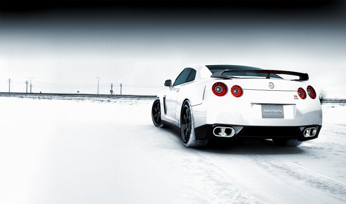 White Nissan car on the road full with snow