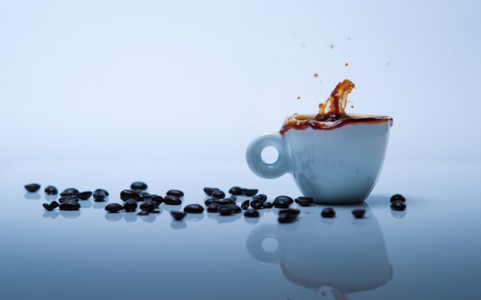 Coffee beans splash in a white cup full with coffee