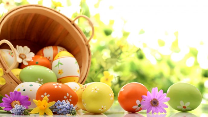 Wooden basket full with colorful Easter eggs - Spring season