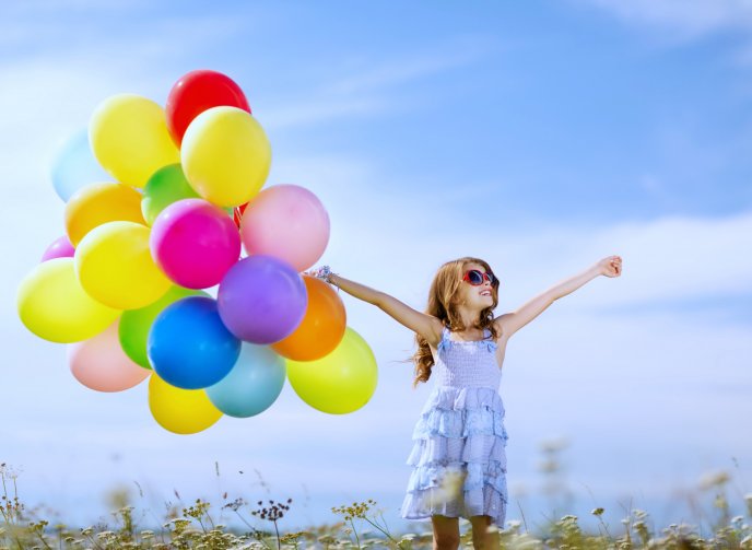 Happy girl with a bouquet of colourful balloons - Childhood