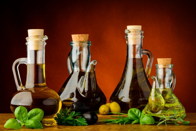 Oils bottle with different vegetable oils -olive basil plant